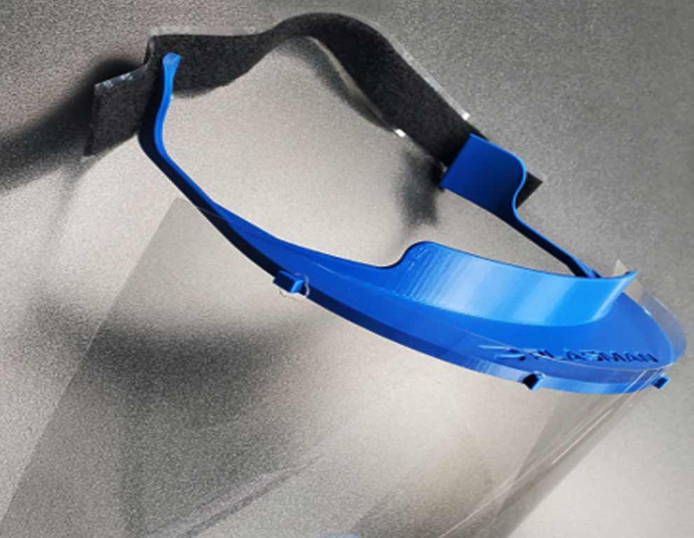 Personal protective equipment with a head strap and face guard used by Plasman employees