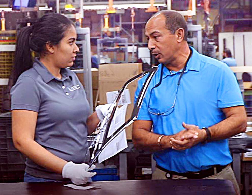 Mojie Mirsalimi, VP, Process on plant floor having discussion with employee