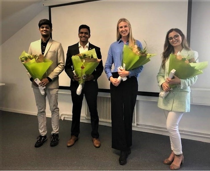 Four students holding bouquets of flowers at Plasman Europe Headquarters