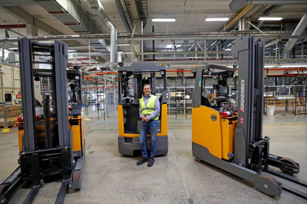 Person in safety vest standing in front of forklift with two other forklifts around him on the factory floor at Plasman Simrishamn Manufacturing
