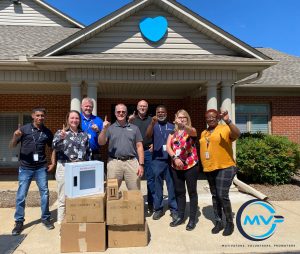 Group of Plasman Greer Manufacturing MVPs donating defibrillators to Southeastern Children's Home holding up #1 finger