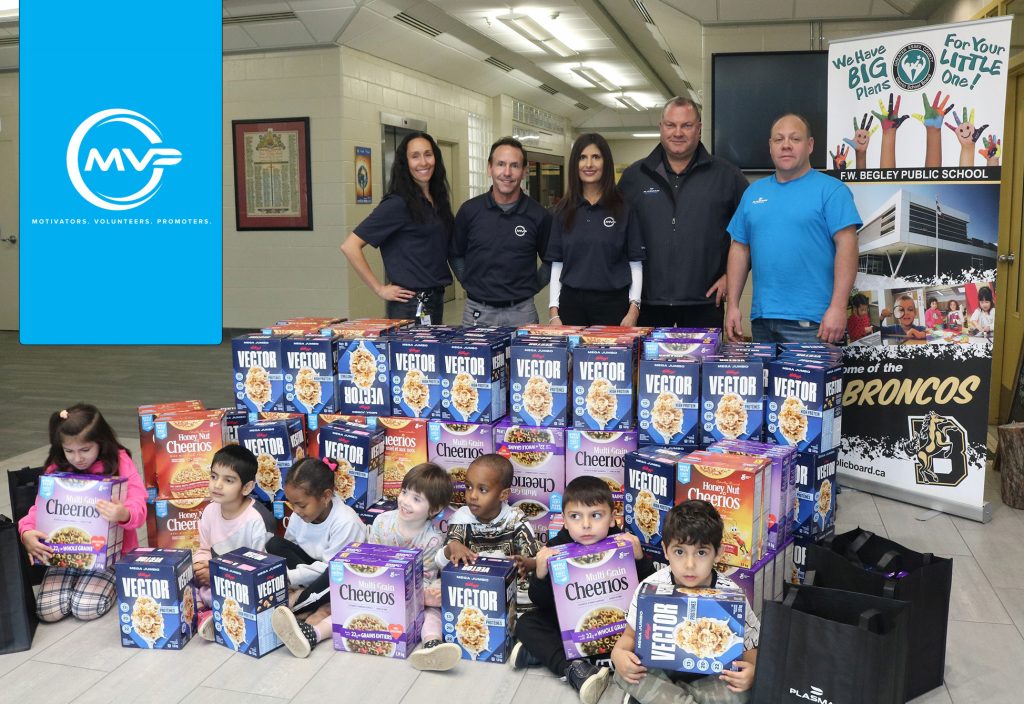 Plasman MVP employees and young students pose around large donation of cereal boxes to Begley Public School