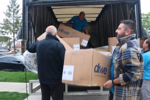 3 men unloading a truck of boxes that have mattresses in them
