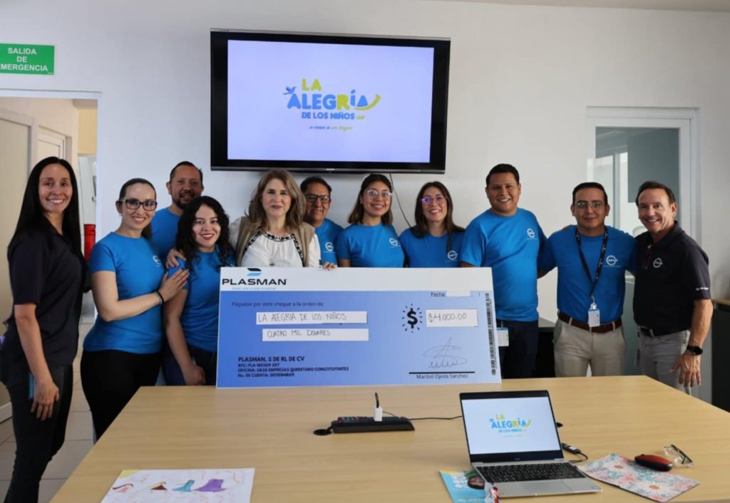 Group of MVPs standing with the coordinator of La Alegra holding a big cheque for $5,000 USD