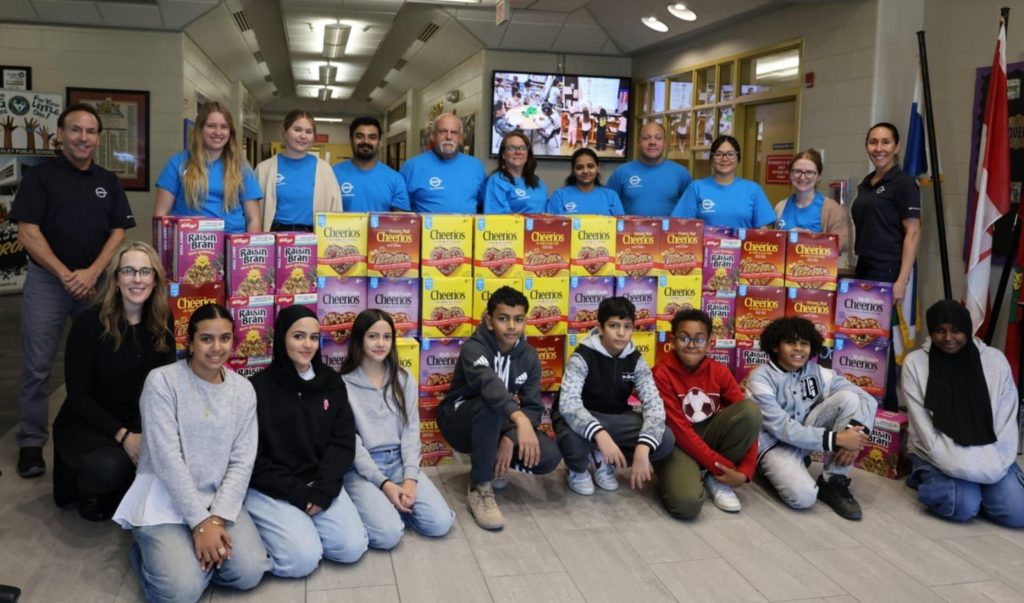 Group of MVP ambassadors behind over 200+ cereal boxes with kids sitting in front of the boxes