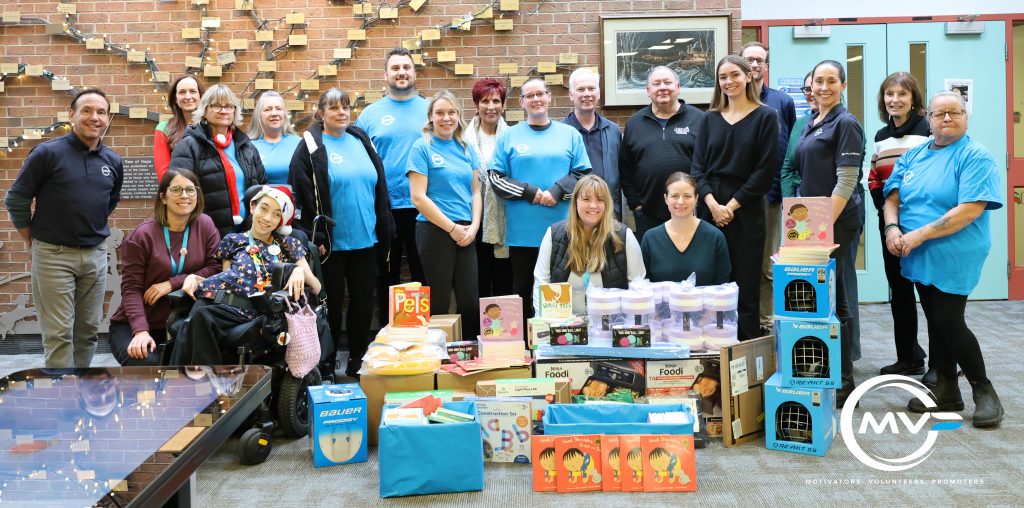Group of CCTC employees and Plasman MVP ambassadors standing around donations