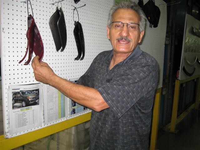 Moe posing with an automotive part