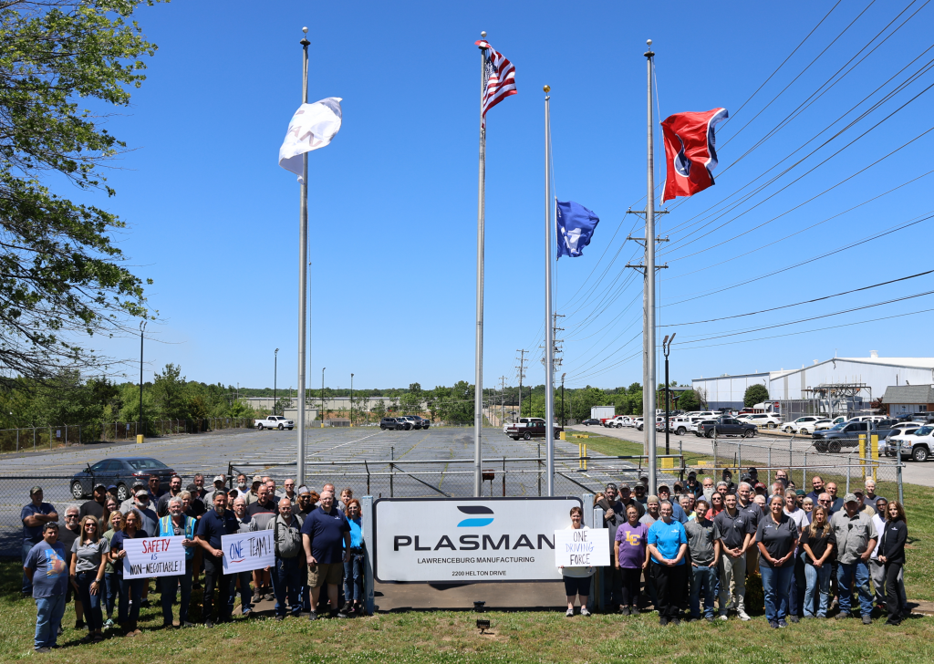 Entire Lawrenceburg Manufacturing team standing in front of the flag pole with the Ford Q1 flag raised