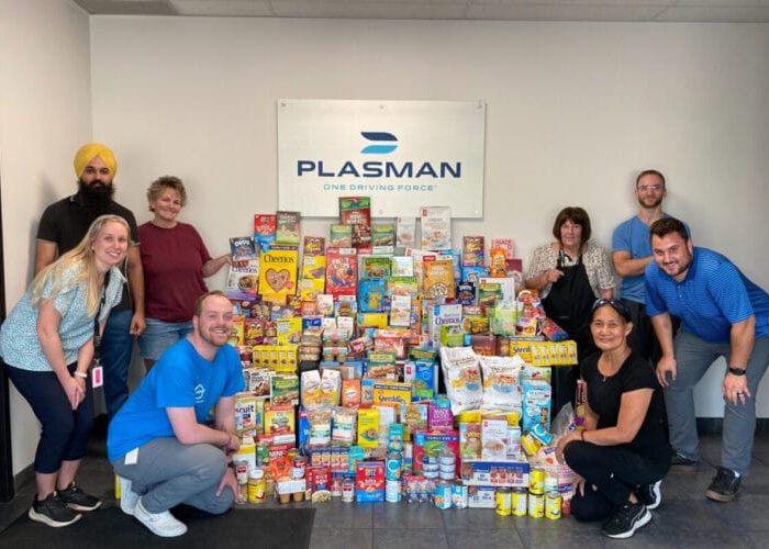 Plasman Windsor 3 Manufacturing employees standing around large pile of cereal and food for donation